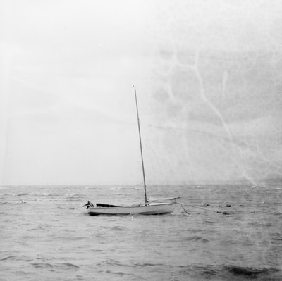 帆船停泊在沙滩上的灰度照片